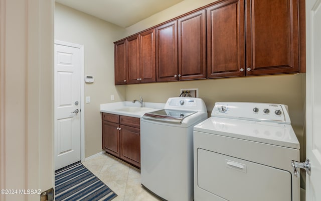 laundry room with light tile patterned flooring, cabinets, sink, and washing machine and dryer