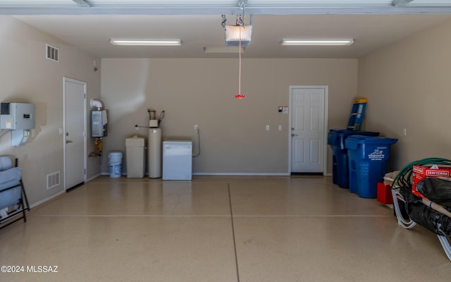 garage with a garage door opener and water heater