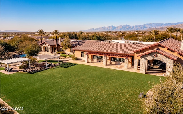 rear view of property with a mountain view, a lawn, a patio area, and a pergola