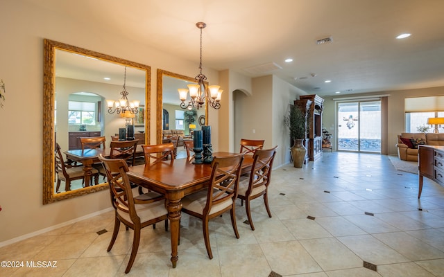 dining area featuring plenty of natural light, light tile patterned floors, and a chandelier