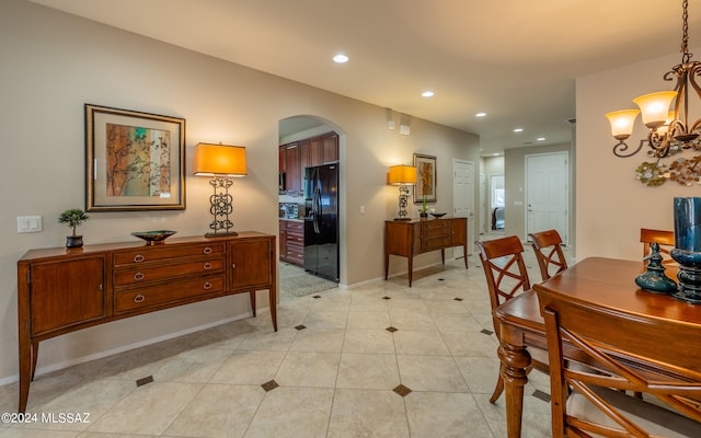 dining area featuring light tile patterned flooring and an inviting chandelier