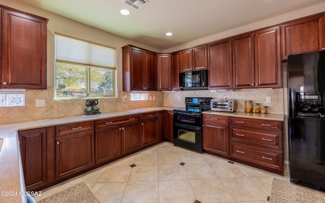 kitchen featuring backsplash, light tile patterned floors, and black appliances