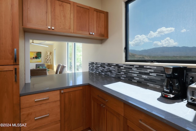 kitchen with a mountain view, backsplash, and kitchen peninsula