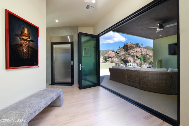 interior space with hardwood / wood-style floors, ceiling fan, and elevator