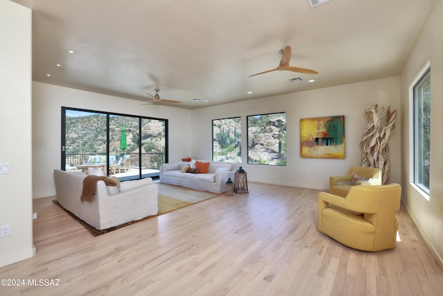 living room with light wood-type flooring and ceiling fan