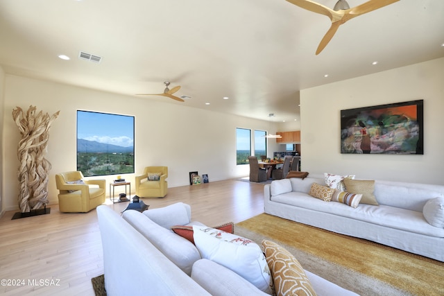 living room with ceiling fan and light hardwood / wood-style floors