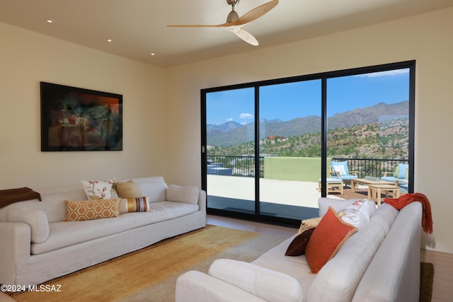 living room with a healthy amount of sunlight, a mountain view, and ceiling fan