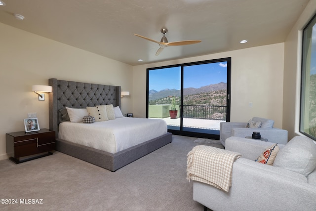 carpeted bedroom featuring ceiling fan, a mountain view, and access to exterior