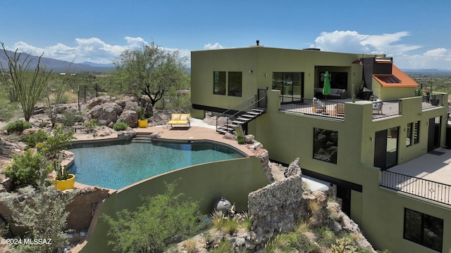 rear view of house with a patio area, a mountain view, and a balcony