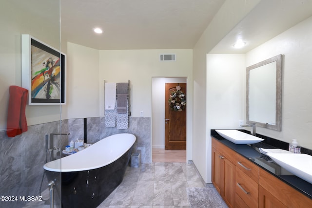 bathroom featuring vanity, a bath, and tasteful backsplash