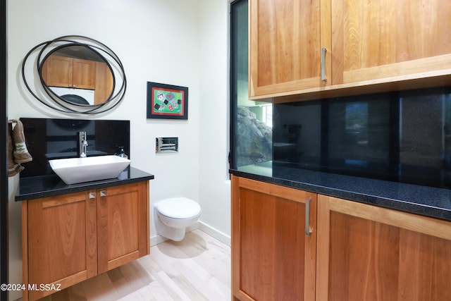 bathroom with vanity, toilet, and wood-type flooring