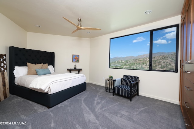 carpeted bedroom featuring ceiling fan and a mountain view