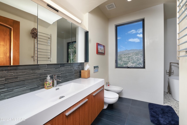 bathroom featuring toilet, tile patterned floors, a bidet, vanity, and decorative backsplash