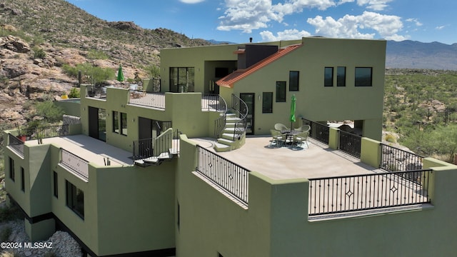 exterior space with a mountain view, a patio area, and a balcony