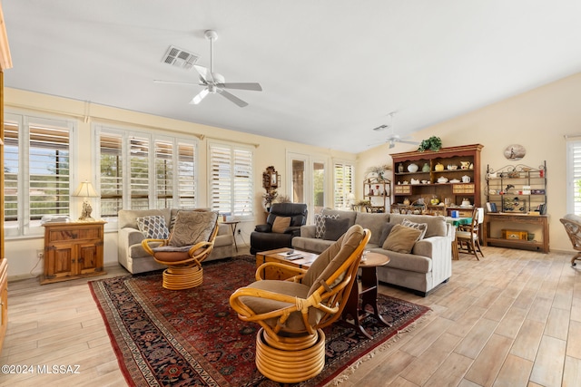 living room with ceiling fan, vaulted ceiling, and light hardwood / wood-style flooring