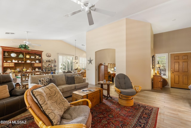 living room featuring light wood-type flooring, ceiling fan, and vaulted ceiling