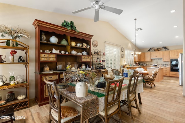 dining space with lofted ceiling, ceiling fan, and light wood-type flooring