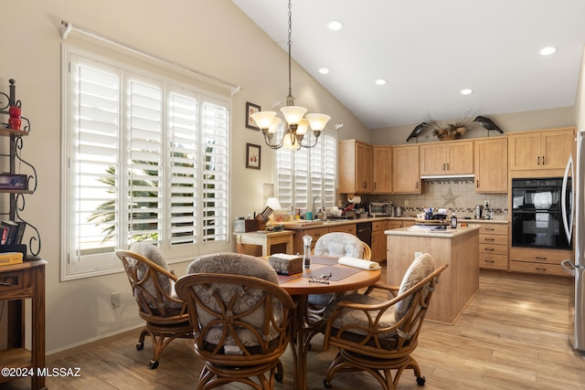 interior space with a kitchen island, an inviting chandelier, light hardwood / wood-style floors, hanging light fixtures, and lofted ceiling