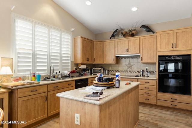 kitchen featuring light hardwood / wood-style flooring, black appliances, a kitchen island, sink, and lofted ceiling