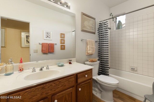 full bathroom with hardwood / wood-style floors, shower / bath combination with curtain, toilet, and vanity