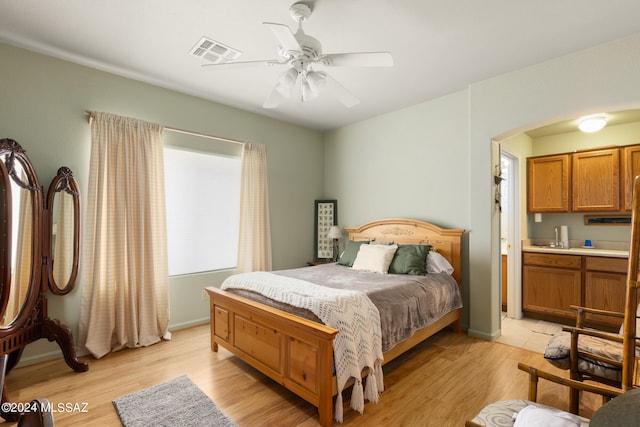 bedroom featuring connected bathroom, ceiling fan, and light hardwood / wood-style floors