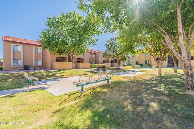 view of home's community featuring a lawn and a patio