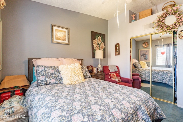 carpeted bedroom with a textured ceiling, ceiling fan, and a closet