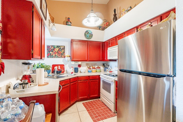 kitchen with white appliances, light tile patterned flooring, sink, and decorative light fixtures