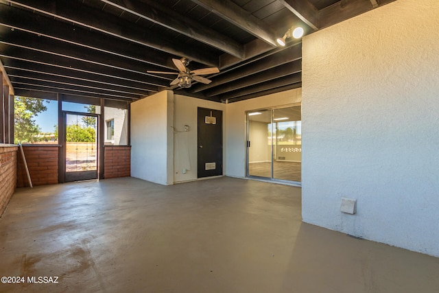 empty room with concrete flooring, ceiling fan, and beam ceiling