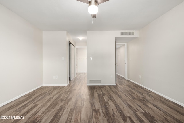 empty room with dark wood-type flooring and ceiling fan