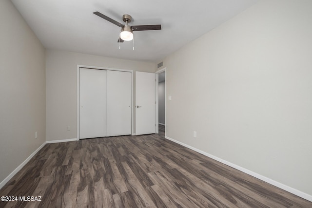 unfurnished bedroom with ceiling fan, a closet, and dark hardwood / wood-style flooring