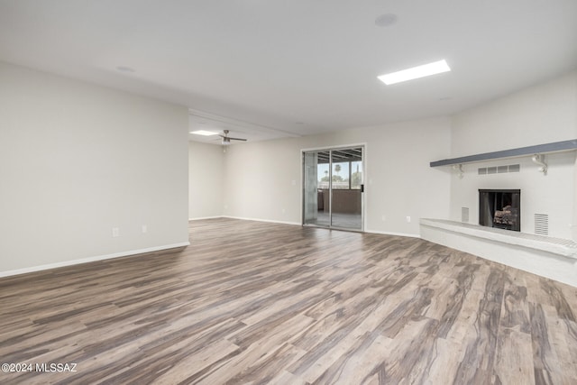 unfurnished living room featuring ceiling fan and hardwood / wood-style floors