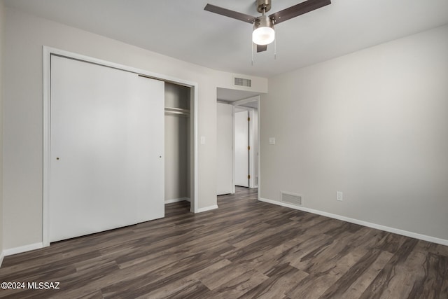 unfurnished bedroom with ceiling fan, a closet, and dark hardwood / wood-style flooring