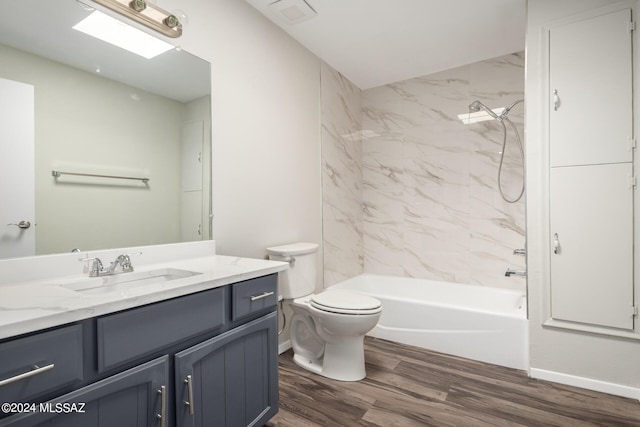 full bathroom with tiled shower / bath combo, vanity, toilet, and hardwood / wood-style flooring