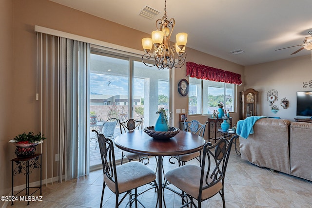 tiled dining room featuring ceiling fan with notable chandelier