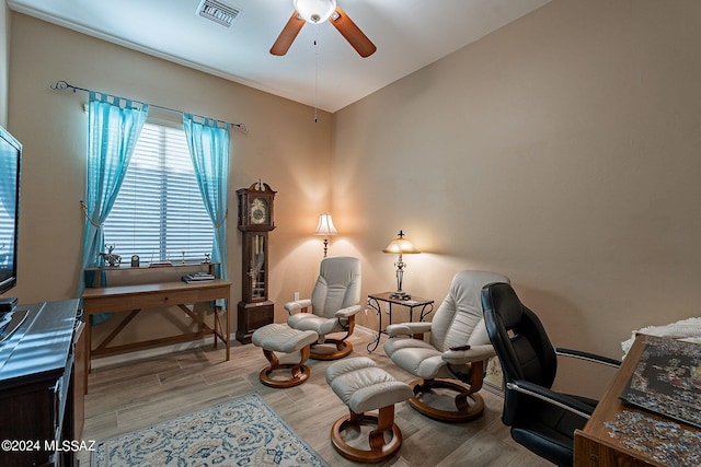 living area with ceiling fan and light hardwood / wood-style flooring