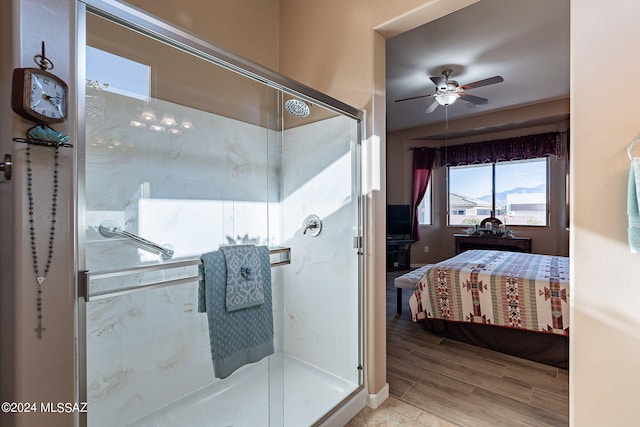 bathroom featuring wood-type flooring, a shower with door, and ceiling fan