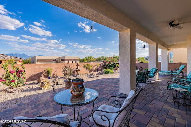 view of patio / terrace featuring ceiling fan and a mountain view