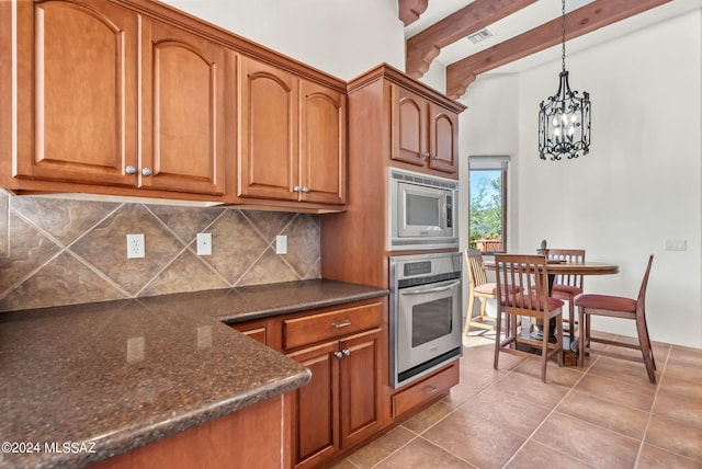 kitchen with an inviting chandelier, light tile patterned floors, hanging light fixtures, stainless steel appliances, and decorative backsplash