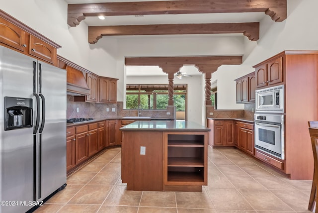 kitchen with appliances with stainless steel finishes, sink, light tile patterned flooring, a kitchen island, and tasteful backsplash