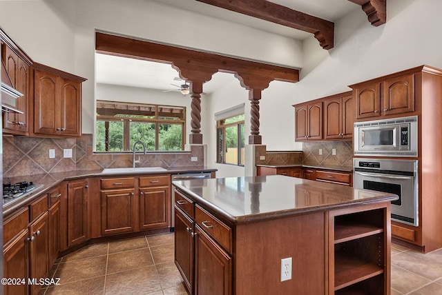 kitchen with a center island, stainless steel appliances, sink, and tasteful backsplash