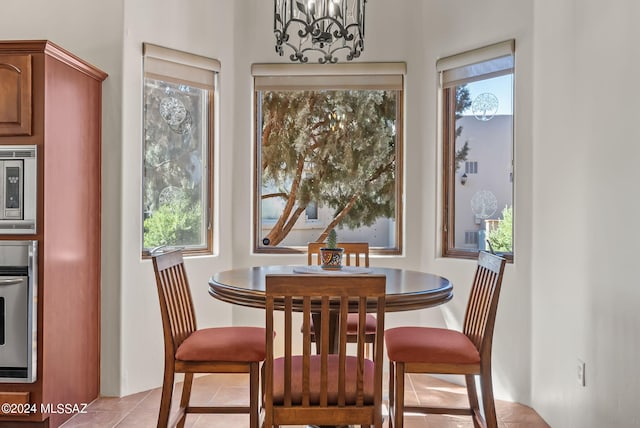 dining space with a healthy amount of sunlight, an inviting chandelier, and light tile patterned flooring