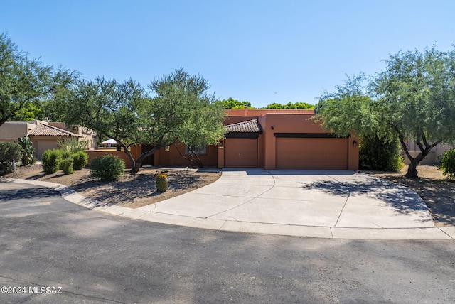 pueblo-style house featuring a garage