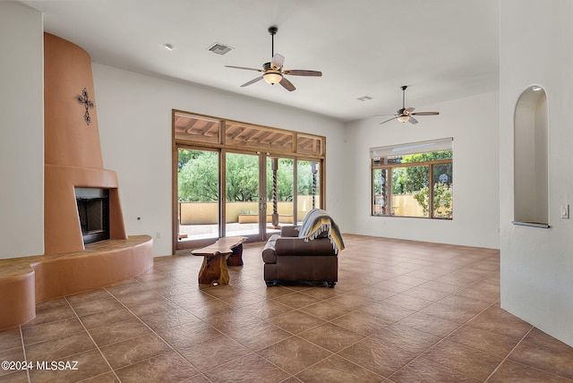 living room featuring a fireplace, french doors, and ceiling fan