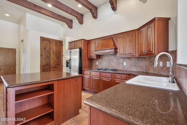 kitchen with stainless steel appliances, light tile patterned floors, a kitchen island, premium range hood, and sink