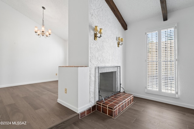 unfurnished living room with vaulted ceiling with beams, dark hardwood / wood-style floors, a fireplace, and an inviting chandelier