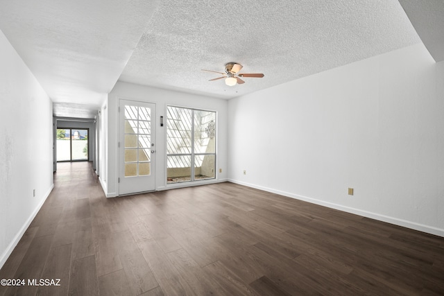 unfurnished living room featuring a textured ceiling, ceiling fan, and dark wood-type flooring