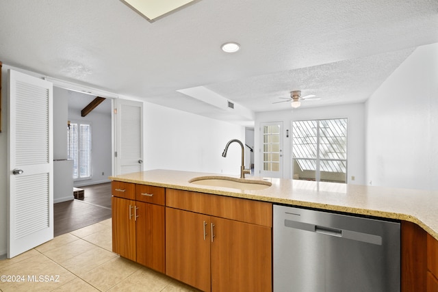 kitchen featuring stainless steel dishwasher, ceiling fan, sink, light tile patterned floors, and beamed ceiling