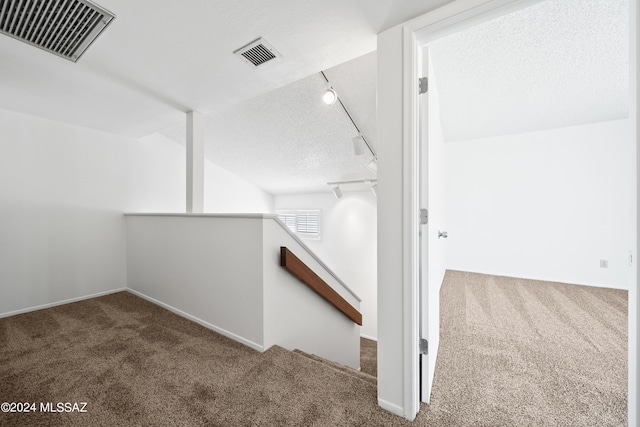 bonus room featuring a textured ceiling and carpet floors