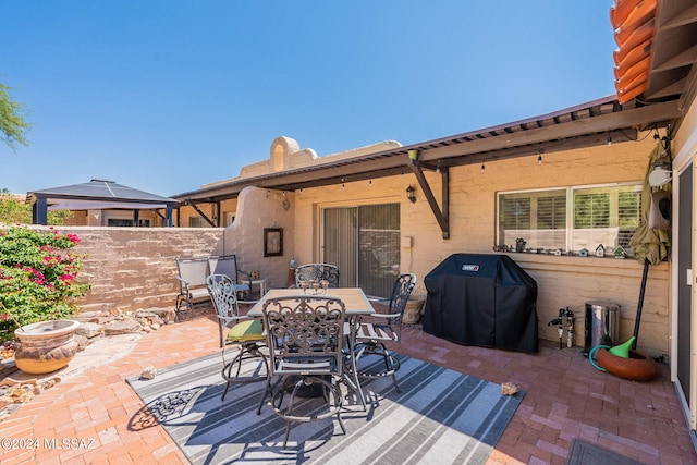 view of patio / terrace with fence, outdoor dining space, and grilling area